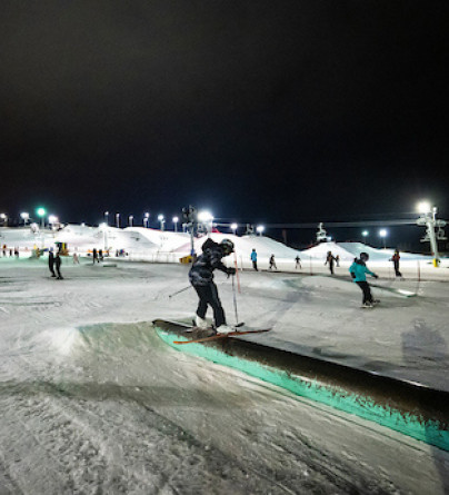 Young skiier on a rail at WinSport on a beautiful winter night