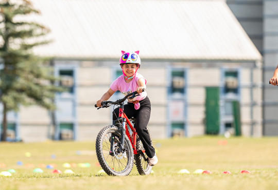Young biker learning how to ride a bike properly during a mountain bike camp at winsport