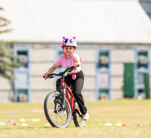 Young biker learning how to ride a bike properly during a mountain bike camp at winsport