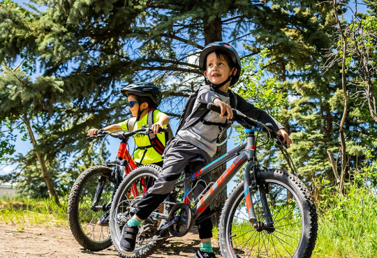 Two kids waiting for their instructor during a mountain bike lessons at winsport