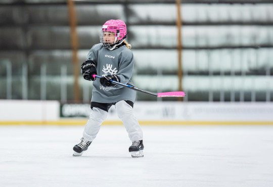 Participant in WinSports girls only hockey camp skating on the hockey rink